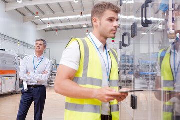 Supervisor watching worker in factory