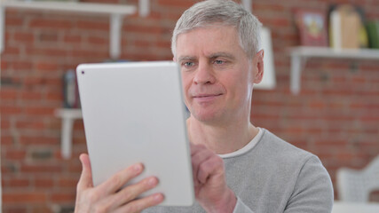 Serious Old Man using Tablet