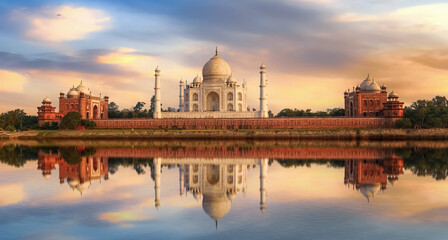 Taj Mahal Agra India at sunset with moody sky and water reflections on river Yamuna.	