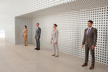 Serious business people standing in front of metallic wall