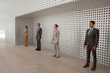 Serious business people standing in front of metallic wall