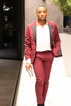 African-American Man In Red Suit Walking Towards The Camera