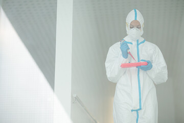 Naklejka premium Scientist in clean suit with pipette and tray