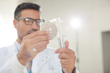 Scientist using caliper