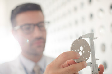 Scientist using caliper