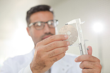 Scientist using caliper