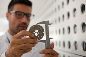 Scientist using caliper