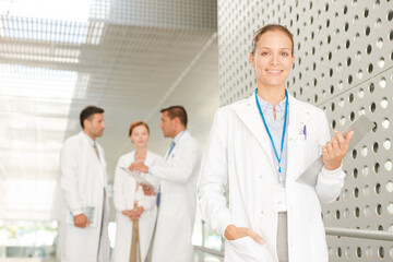 Female doctor with clipboard in hospital corridor