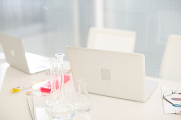 Close up of laptop and  beakers at desk