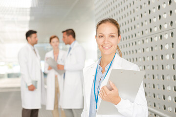 Doctor with clipboard in hospital corridor