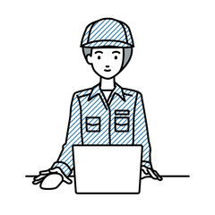 デスクで座ってPCを使っている作業員の女性