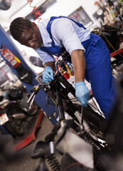 Service engineer repairs a motorcycle steering wheel in a motorcycle service. High quality photo