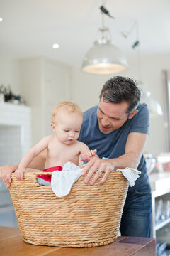 Father Carrying Baby In Laundry Basket