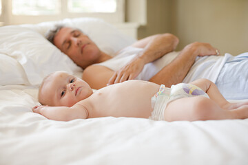 Father and baby laying on bed