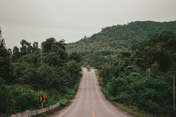 A view of the main road in the countryside with hills and covered with forests, both side.