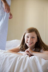 Obraz na płótnie Canvas Smiling girl laying on bed