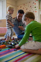 Father and children playing together with toys