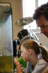 Father and daughter watching turtle swim in tank