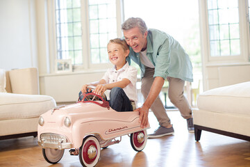 Father pushing son in toy car