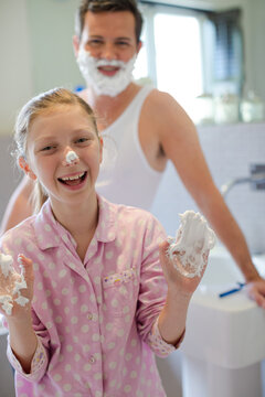 Father and daughter playing with shaving cream