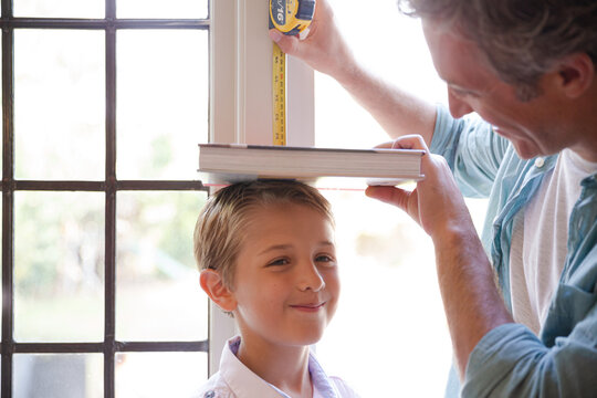 Father Measuring Son's Height On Door