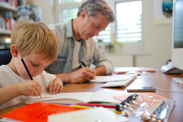 Father and son working in home office