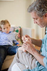 Father bandaging son's foot