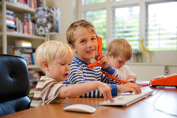 Boys using telephone in home office