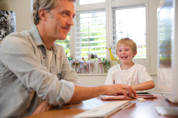 Obraz premium Father and son working in home office