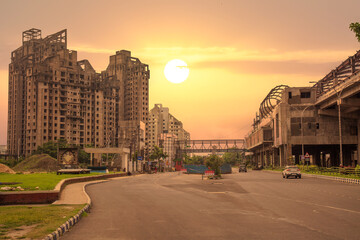 City road with under construction city residential building and apartments at sunrise at New Town area of Kolkata, India