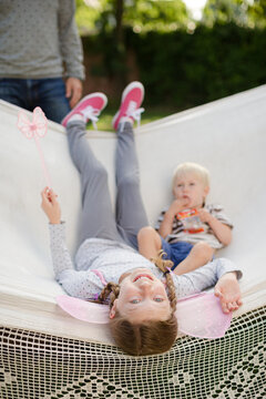 Father pushing children in hammock outdoors