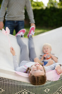 Father pushing children in hammock outdoors