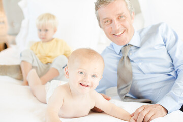 Father and children relaxing on bed
