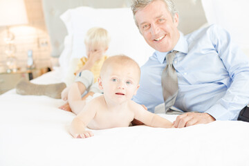 Father and children relaxing on bed