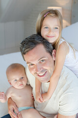 Father and children hugging in bedroom