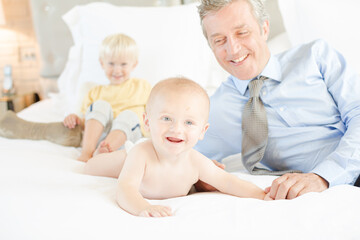 Father and children relaxing on bed