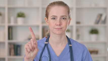 Serious Young Female Doctor saying No by Finger Sign