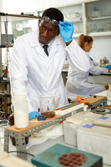 Serious male scientist with test tubes checking for result of chemical experiment