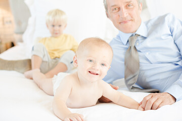 Father and children relaxing on bed