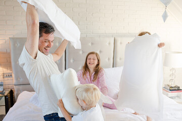 Obraz na płótnie Canvas Father and children having pillow fight