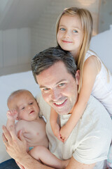 Father and children hugging in bedroom