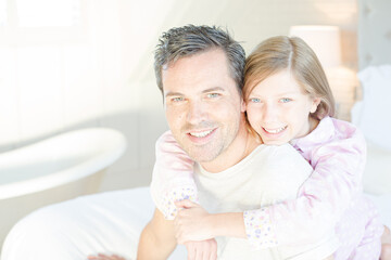 Father and daughter hugging on bed