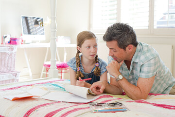Father helping daughter with homework