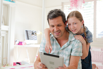 Father and daughter using digital tablet