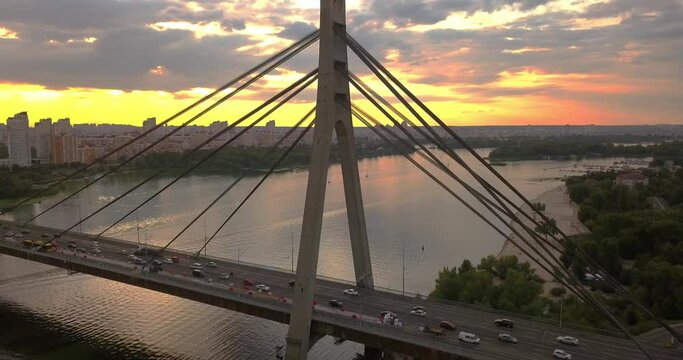 Aerial drone view of Road bridge over Dnieper river. Sunset in Obolon district, Kiev, Eastern Europe