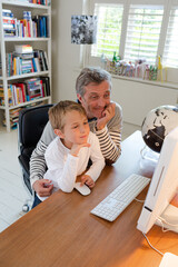 Father and son using computer together