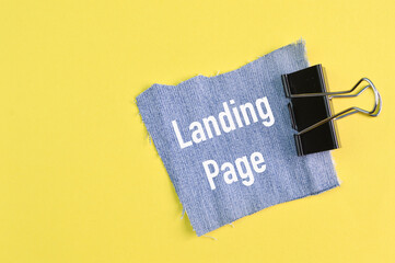 Ripped pieces of jeans with text LANDING PAGE isolated on a yellow background