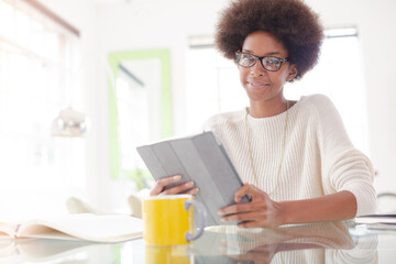 Woman using digital tablet at table