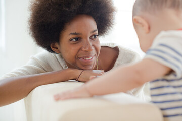 Mother and baby boy sitting on sofa