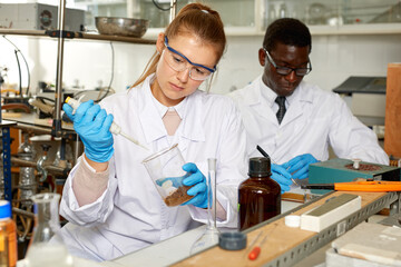 Young woman scientist working in research laboratory performing experiments in laboratory